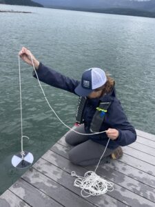 CSISS staff lowering secchi disc into water from a dock.